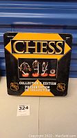 Front and side view of NHL Hockey Chess collector's edition metal game box featuring images of player and referee chess pieces.