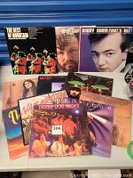 Photo showing multiple rock vinyl record albums including The Best of Mountain, Joe Walsh, Bobby Darin, Angel City, Three Dog Night, Rubicon, and others.
