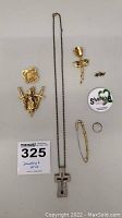 Full overview of necklace and various pins including coat of arms pins, rose pin, silver ring, safety pin style brooch, and circular Sharing pin.