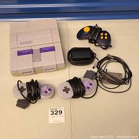 Full lot showing SNES console, two wired controllers, joystick controller, power adapter, and AV cable.
