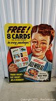 Full view of the vintage Kellogg's All-Wheat stand-up cardboard advertisement showing the boy holding the cereal box and promotional text on a concrete floor against a white corrugated wall.