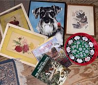Photo showing various framed art prints, two books, and a poker chip set with playing cards
