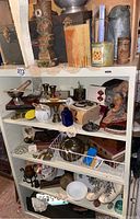 Five shelves filled with assorted vintage and collectible items including sculpture, medals, and various household objects.