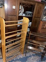 Vintage wooden racks visible in front of a vintage china cabinet displaying fine china dishes inside. Shows detail of construction and condition of racks.