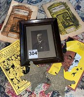 Overview of entire lot showing two metal Civil War markers, framed portrait, and five books.