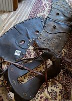 View of three vintage saddles, prominently showing the Canadian Mountie saddle with distinctive metal studs and engraved lettering on leather.