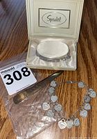 Overall view of all three items on wood surface: charm bracelet, ID bracelet in Speidel box, letter opener.