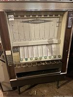 Front view of the vintage candy machine showing candy selection area and coin knobs.