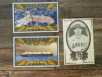 Three cards laid out on a wood surface: Mike Trout portrait card in sepia tone, World's Largest Giant Squid card, and World's Largest Tanker Ship card with blue and brown backgrounds respectively.