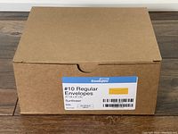 Closed brown cardboard box labeled '#10 Regular Envelopes' showing sunflower yellow color indication and quantity of 500.
