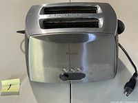 Front view of stainless steel Breville Ikon toaster showing two wide slots with bagel function, control buttons and knob on front.