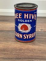 Front view showing bee hive graphic and brand text on blue background