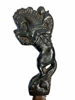 Front close-up showing detailed bronc busting cowboy figure as handle of letter opener, bronze/brass material with dark patina.