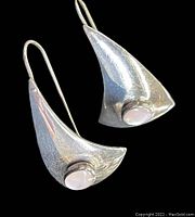 Pair of sterling silver earrings with iridescent mother of pearl cabochon stones, shown on black background.