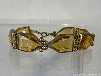 Close view of the bracelet showing facets and gold-tone metal setting