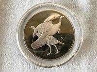 Front side of the medal showing detailed engraved design of wild turkeys and artist signature.