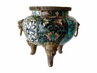Front view of pot showing cloisonné floral patterns on black and turquoise panels