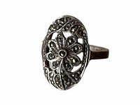 Close up photo of the ring face showing marcasite stones set around a daisy flower filigree design on an oval shaped top.