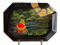 Front view of the black octagonal metal tray showing the hand-painted frog character and pond scene with the striped curtain detail.