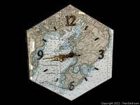 Full view of hexagon-shaped clock with nautical chart of Gloucester Harbor under glass.