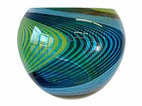 Side view of the large round psychedelic Nailsea art glass bowl showing blue and green sweeping swirl lines.