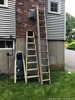 Front view of three ladders set outdoors against a building wall; Werner extension ladder, Keller step ladder, and Tricam step stool.