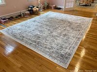 Full view of rectangular area rug laid out on hardwood floor showing the overall design and condition.