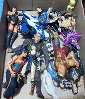 Box containing 15 assorted character toys including female action figures, large ape figure, horse, and knights.