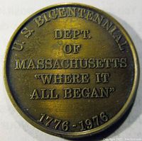 Obverse side of brass bicentennial token showing "U.S. Bicentennial Dept. of Massachusetts Where It All Began 1776-1976" text.
