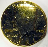 Obverse of the gold plated Kennedy half dollar with double date 1960 and 1985 and 'IN GOD WE TRUST' text.
