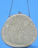 Front view of silver-tone hand beaded round purse showing detailed beadwork on a blue background