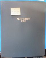 Front cover of blue Mint Sheet File binder with gold “MINT SHEET FILE” text and handwritten note.
