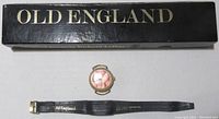 Photo showing Old England watch, original black satin leather strap, and original black box with gold lettering