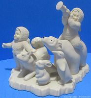Front and side view of the Snow Babies and arctic animals figurine on a blue background.