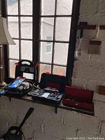 Image of toolboxes and mouse sander arranged on a window ledge under natural light.