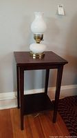 Full view of wooden corner table with electric hobnail glass hurricane lamp on top