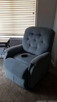 Blue/gray fabric Lazyboy power lift chair with button-tufted backrest and padded arms.