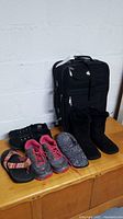 Photo showing all 5 pairs of women's shoes next to black Leisure luggage