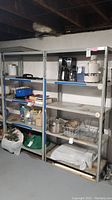 Pair of metal shelving units in a basement environment with items placed on shelves to show scale and condition.