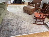 Photo of large beige pile carpet in living room setting with furniture, showing overall size and condition.