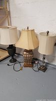 Three table lamps placed side by side showing different bases and shades