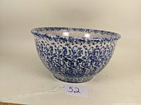 Blue and white spongeware pottery mixing bowl captured from front angle, showing full exterior and rim.