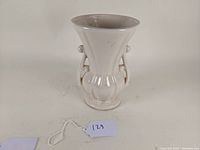 Front view of the 8-inch white ceramic McCoy Pottery vase with handles and bulbous shape