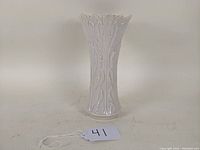 Front view of white Lenox porcelain vase, showing floral raised design and scalloped top edge.