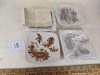 Set includes four porcelain square tidbit plates with Burnished Amber paisley design. Plates are shown alongside original packaging and paperwork confirming brand and pattern.