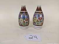 Pair of Satsuma style vases showing overall shape, floral decoration, and colors.