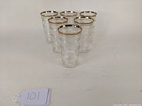 Set of six Hocking Glass Depression Era tumblers arranged in a group showing the pattern and gold rim.