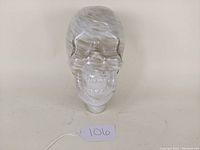 Front view of glass skull showing transparency and internal flecks