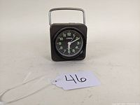 Front view of the vintage Lorus camping clock showing clock face, luminous green numbers and hands, and top handle.
