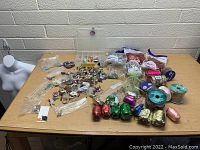 View of entire lot spread on table showing beads, organizer, bags, and spools